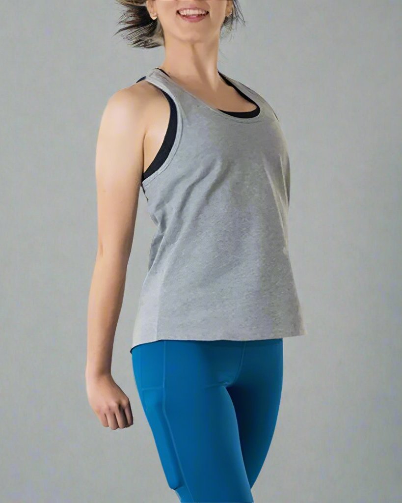 Girl wearing grey tank top with her arms to the side. Tank has scoop neck.