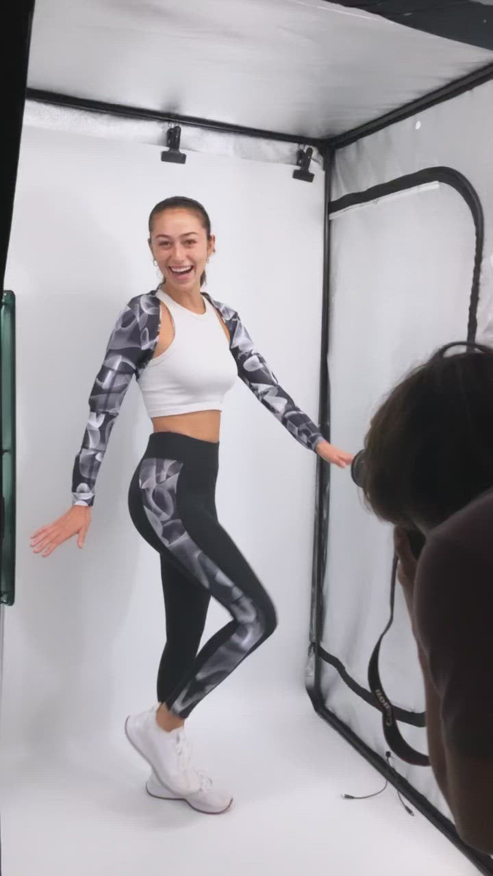video of girl wearing the ghost weighted shrug and the ghost weighted leg, girl turning to the side and kicking her leg