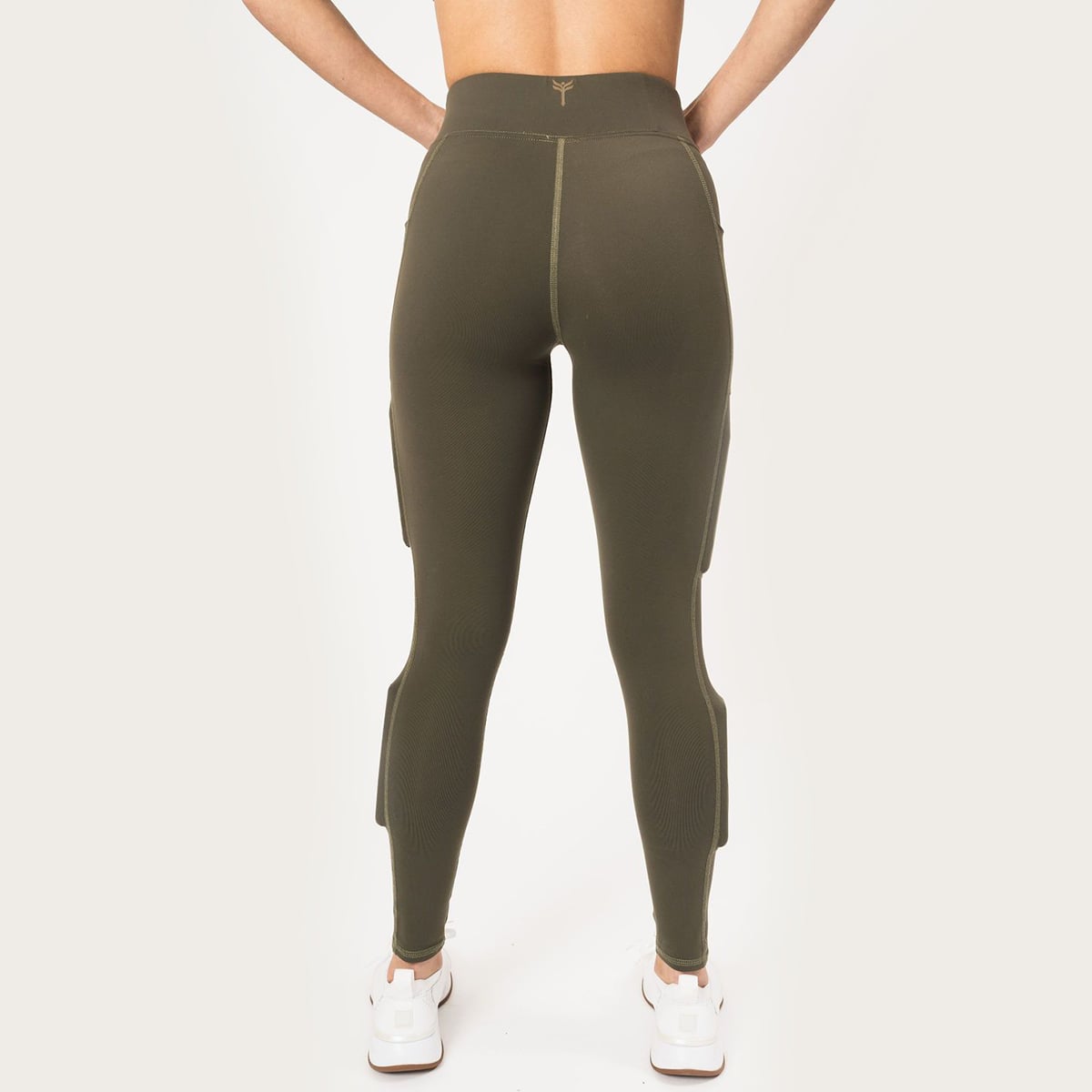 rear view, in the the army green legging called juniper lift, hands down on hips, with white stitch that runs down the leg, weight in the weight pocket above the knee and weight in the below the knee on the side calf.