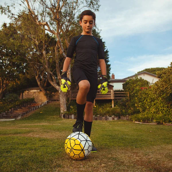 Boy wearing black short sleeve and black top with KILOGEAR weights getting ready to play soccer.