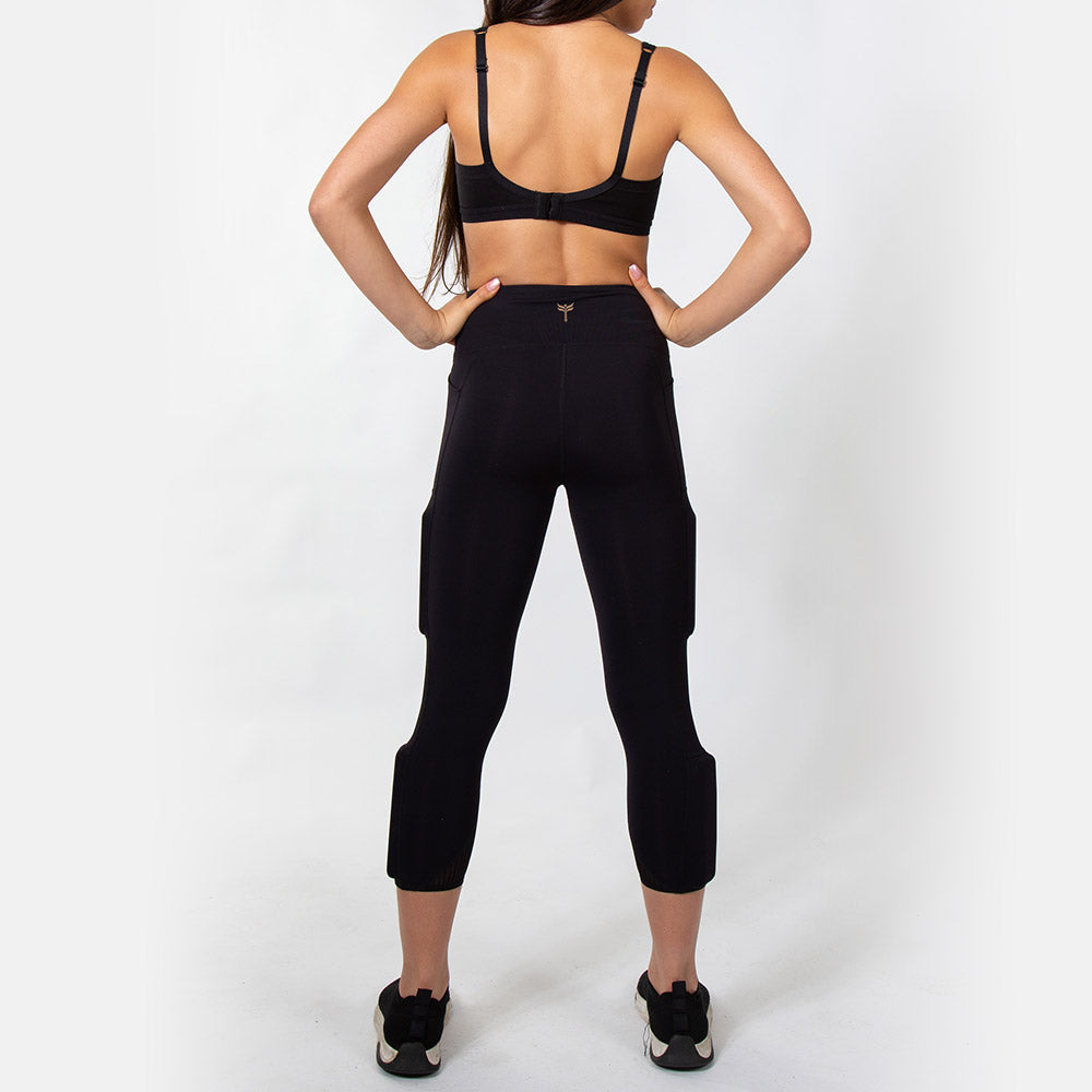 Rear view of the black legging with the kilogear cut logo on the back of the high waistband, weights on the side of the leg with one above the knee on the side and one below the knee on the side calf.