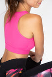 Rear facing image of the hot pink sports bra with razor back and kilogear cut logo in the center back
