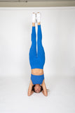 Woman doing a handstand wearing the royal blue weighted legging and the royal blue ribbed bra