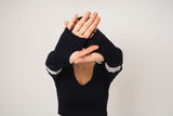 Model is holding her hands up, showing the long sleeve has thumbs holes and when worn, the arm sleeve goes over the knuckles and thumb