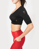 Showing black crop top with scoop neck. Two weight pockets on  the biceps of the arm.